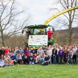 People standing in front of three tractors