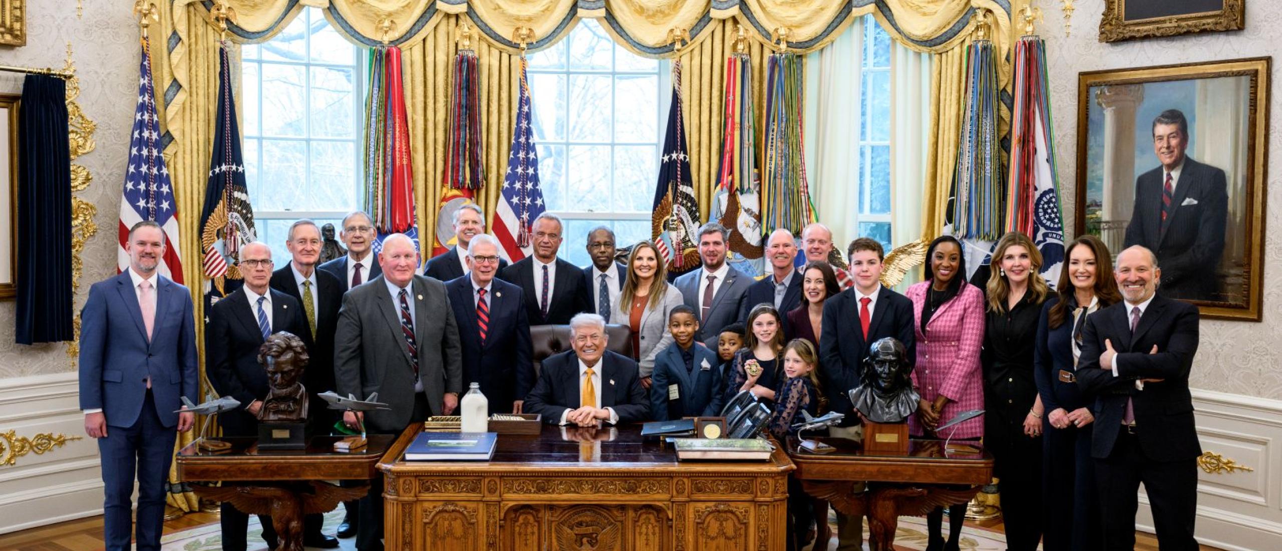 Members of Congress gather with the President before the bill is signed into law
