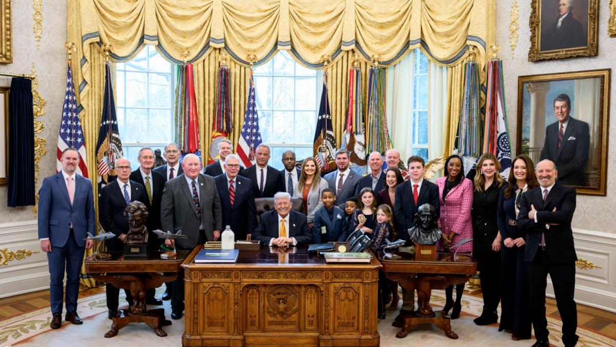 Members of Congress gather with the President before the bill is signed into law